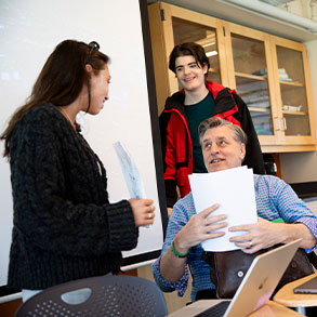 Photo of a teacher having a discussion with two students. Read about Gifts by Estate Note